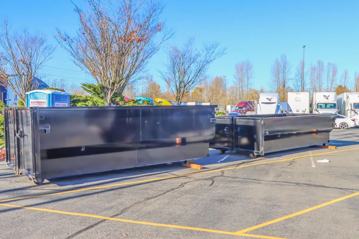 Professional dumpster rental service with roll-off container on residential driveway in Radford